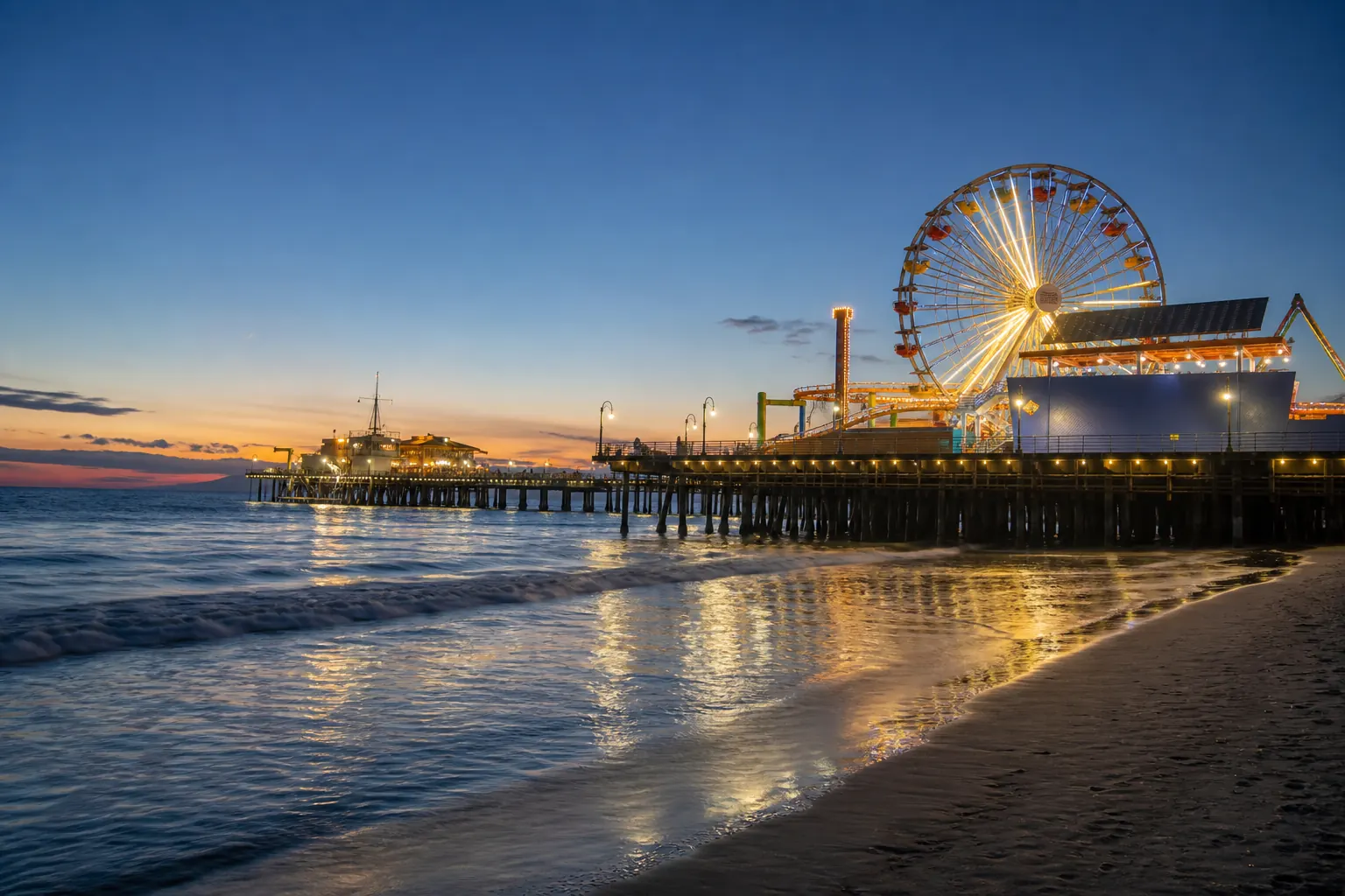 Santa Monica Pier and its illuminated Ferris wheel at sunset.